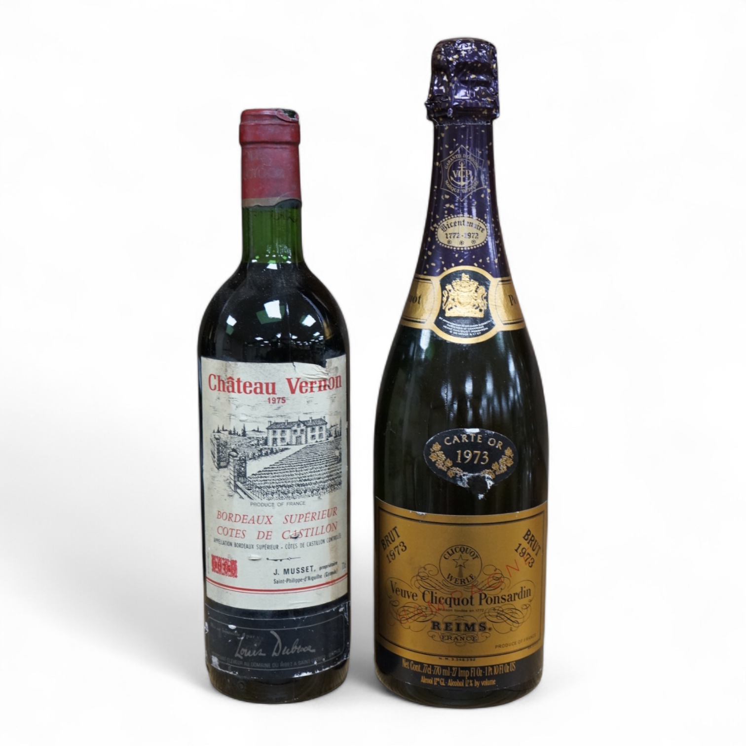 A bottle of 1973 Veuve Clicquot Ponsardin champagne and a bottle of 1975 Chateau Vernon. Condition - fair
